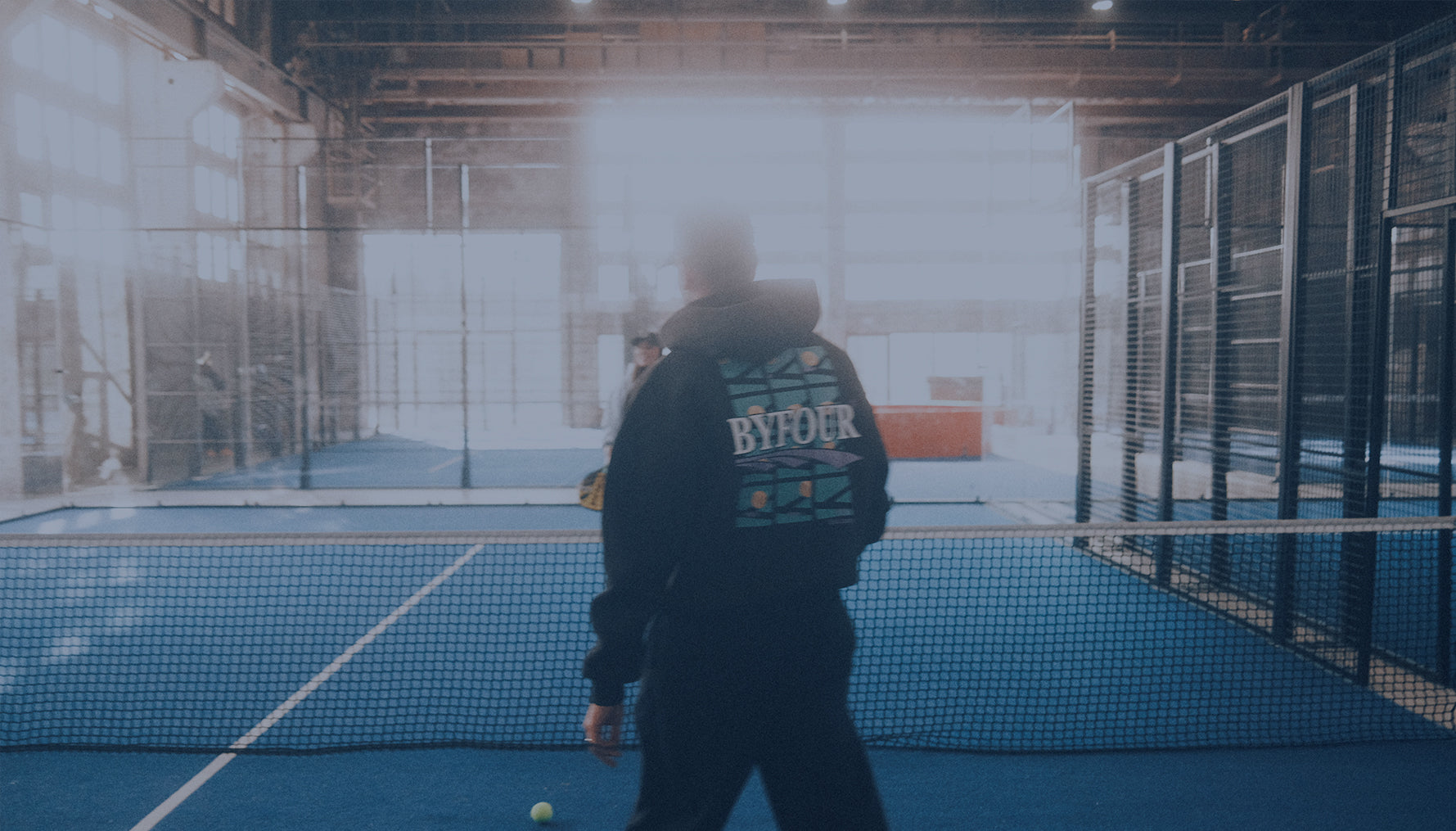 Padel players in BYFOUR hoodie on the court