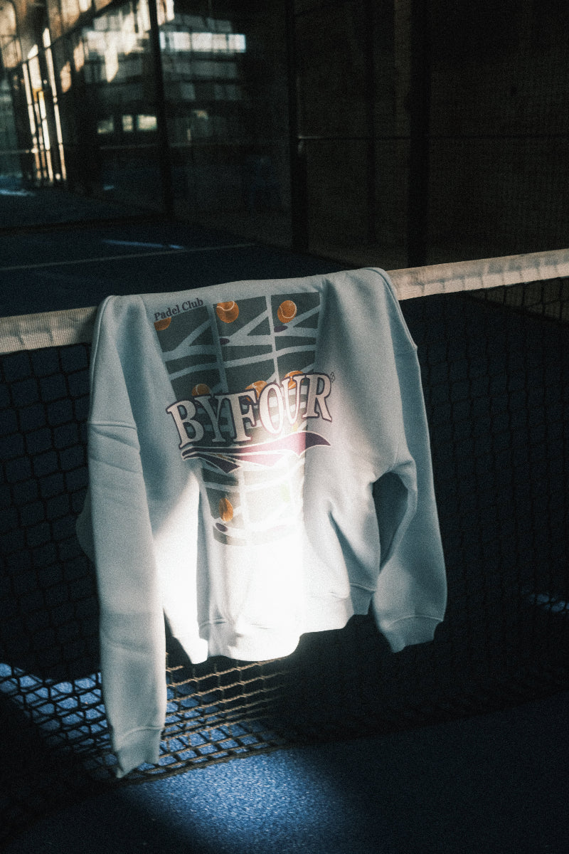 Bandeja Blue BYFOUR Padel hoodie hanging over net